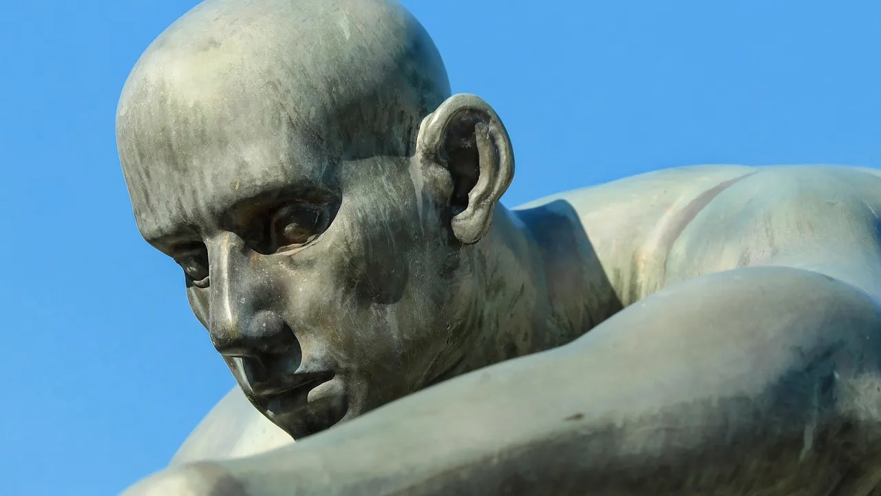 La tête d’une statue de bronze, vue de profil sur fond de ciel